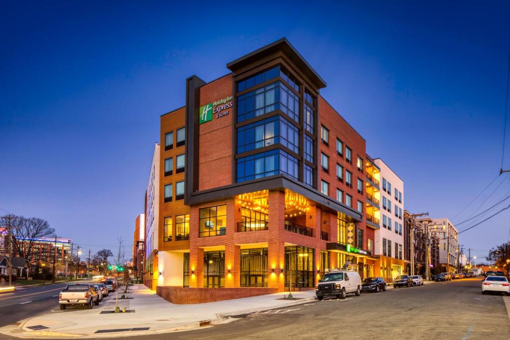 夏洛特Holiday Inn Express & Suites - Charlotte - South End, an IHG Hotel的街道上的建筑物,前面有车辆停放