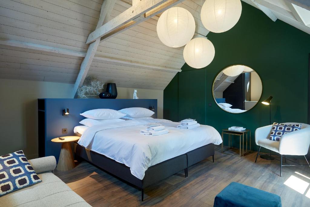 登博斯The Guest Apartments - Uilenburg的一间卧室设有一张大床和绿色的墙壁