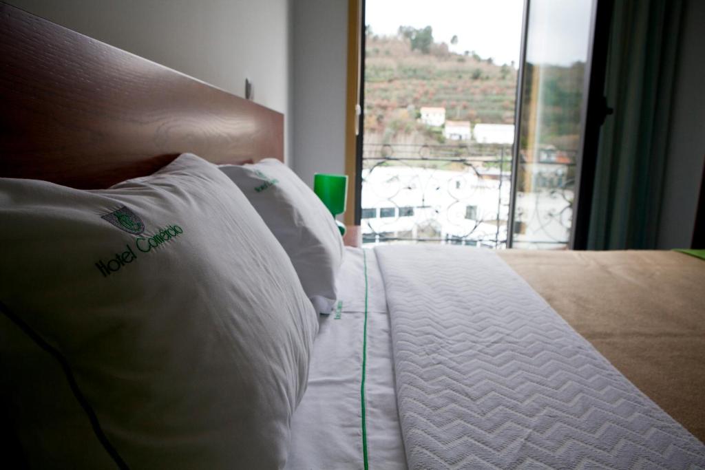 雷森迪科梅西洛酒店的一张带白色枕头和窗户的床