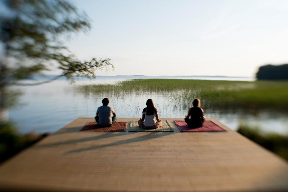 鲁奥科拉赫蒂Utula Nature Retreat的三人坐在靠近水面的码头上