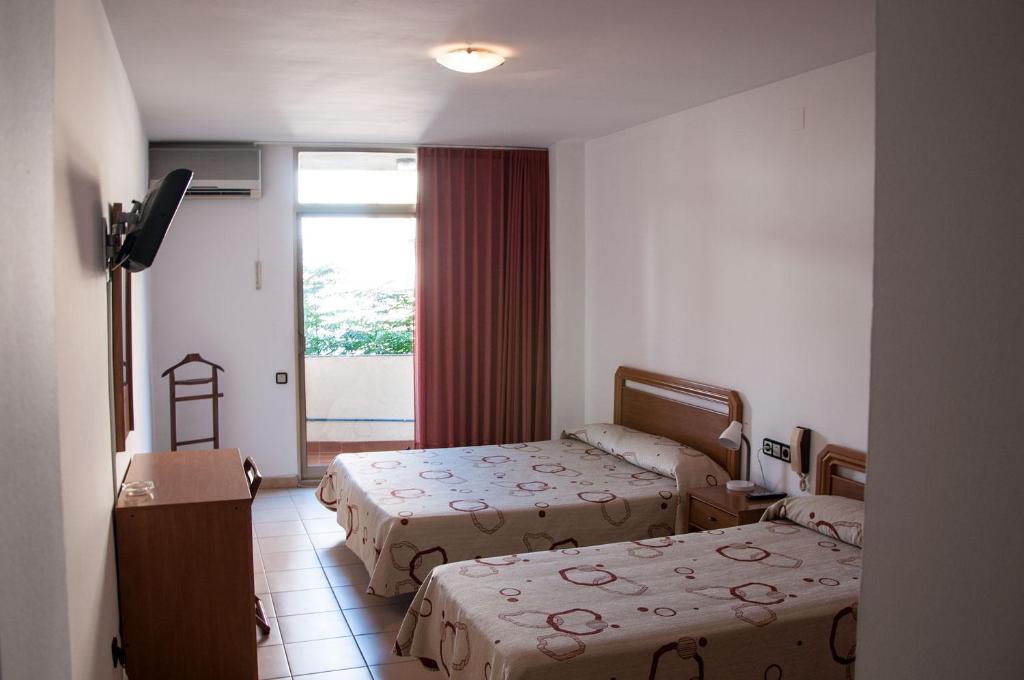 Mora la NuevaHostal Fontdemora的酒店客房设有两张床和窗户。