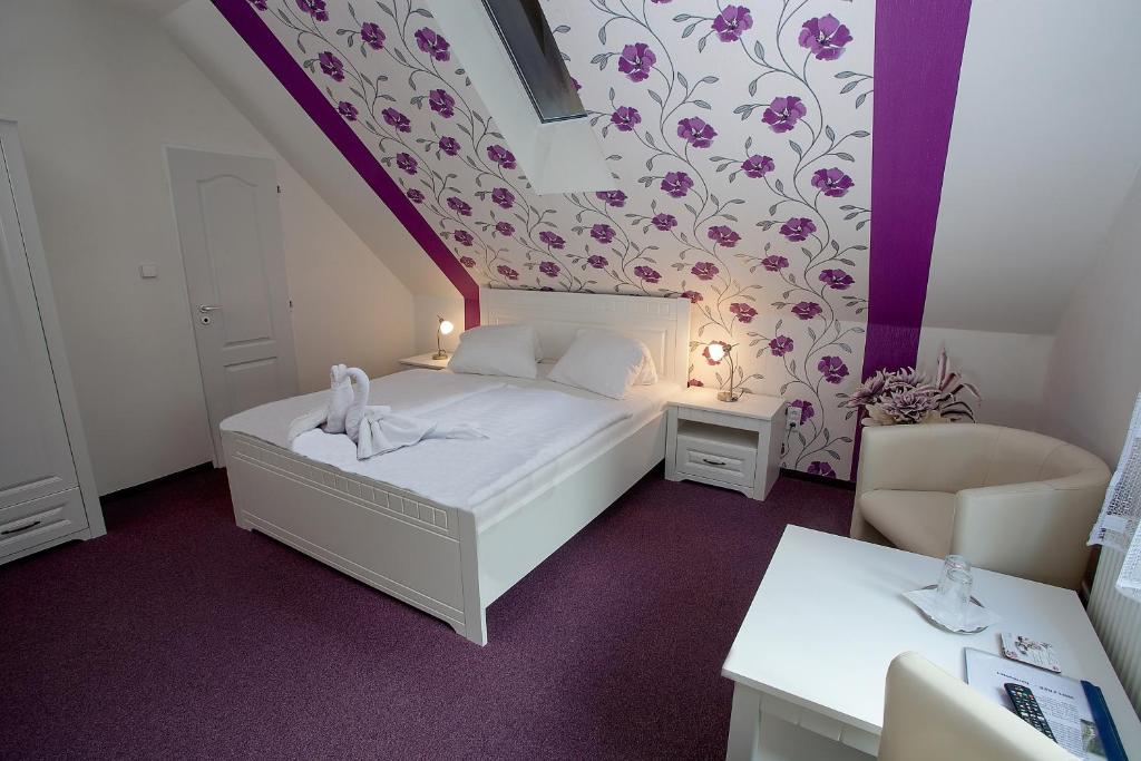 普拉哈季采Wellness penzion Harmonie Rohanov的一间小卧室,配有一张床和紫色的墙壁