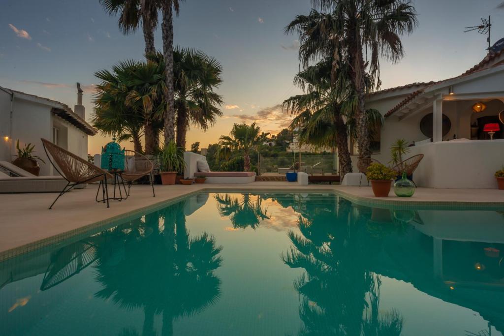 莫莱拉Caballito de Mar Boutique Hotel的一座带棕榈树游泳池的房子