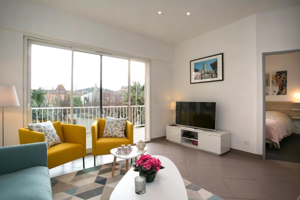 佩里格Agréable maison de ville的客厅配有黄色椅子和电视