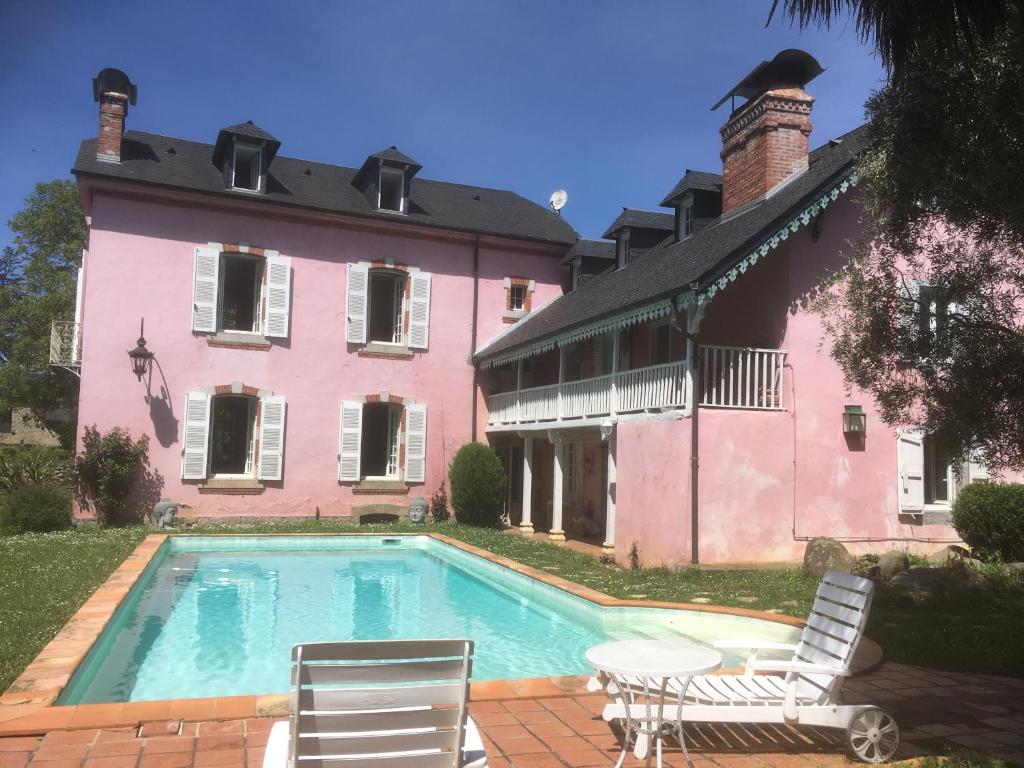 Saint-Pé-de-BigorreChez Mamylette的粉红色房子前的游泳池