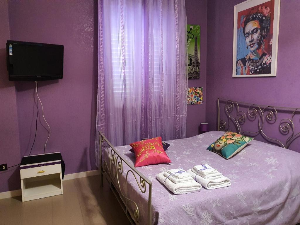 马萨夫拉FRIDA B&B的紫色卧室配有带毛巾的床