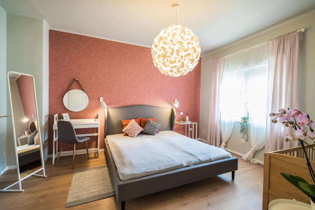 希欧福克Helka Ház的一间卧室配有一张床、一张书桌和一个吊灯。