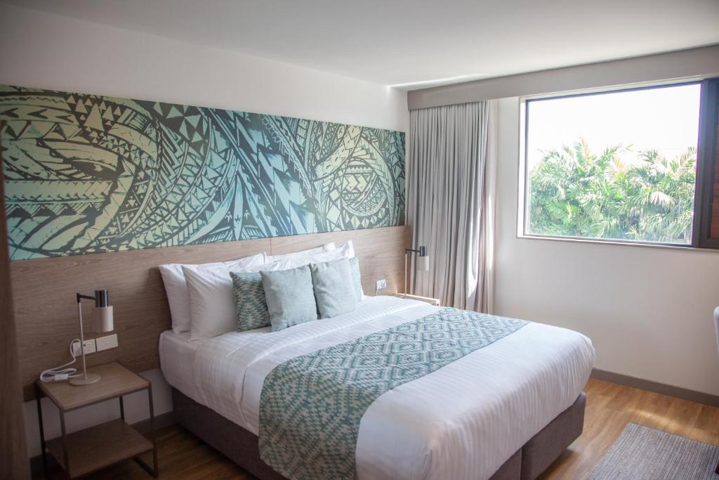 阿皮亚Lava Hotel的一间卧室设有一张大床和大窗户