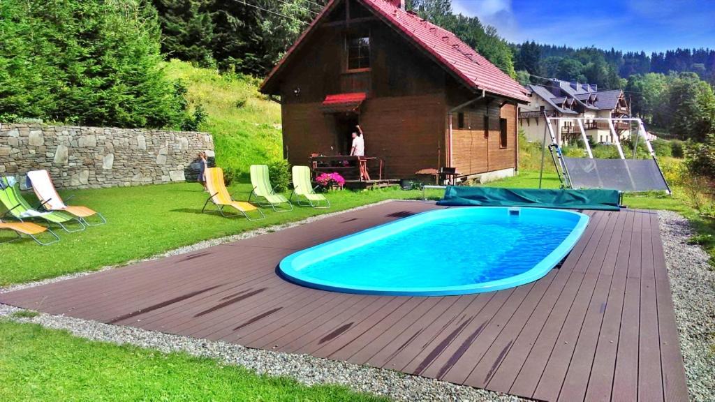 斯托尼拉斯奇Domek Górski Czarna Góra w Siennej的房屋旁的木甲板上的游泳池