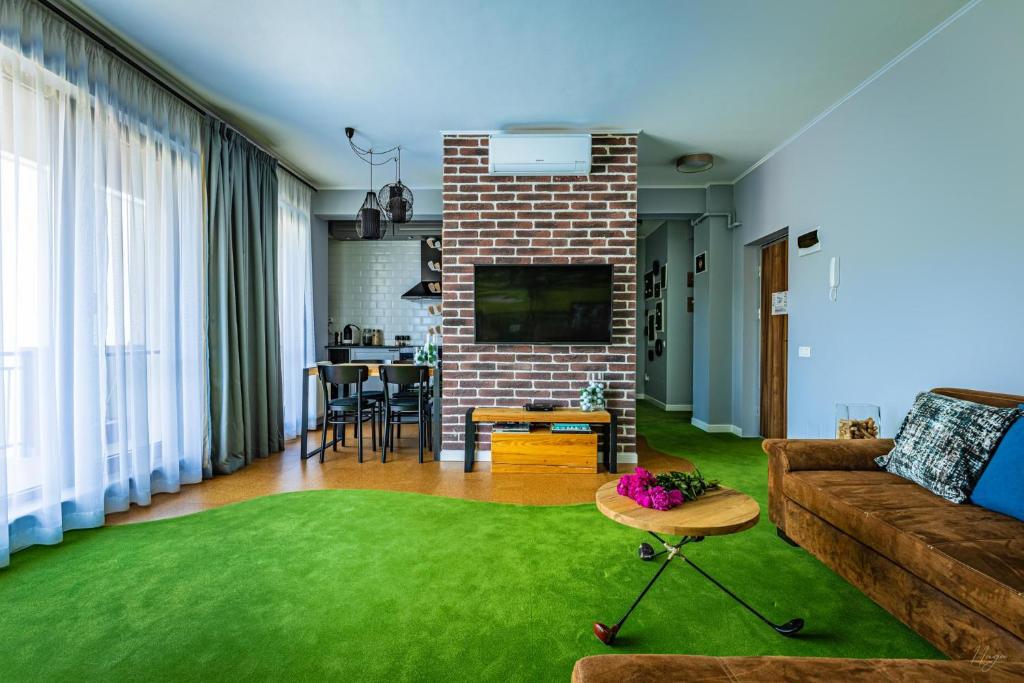 克卢日-纳波卡The Golfer Apartment with Jacuzzi的带沙发和绿色地毯的客厅