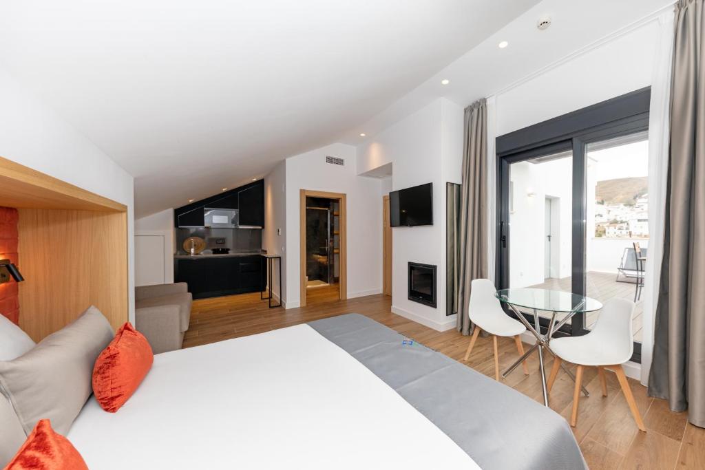 阿达莱斯Apartamentos Ardales Premium的卧室配有白色的床和玻璃桌
