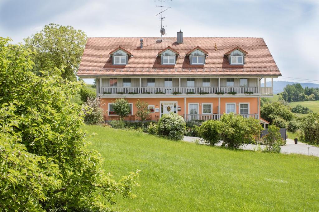 勒赫尔恩巴赫Landhotel Eibl的绿色田野顶部的一座大型橙色房子