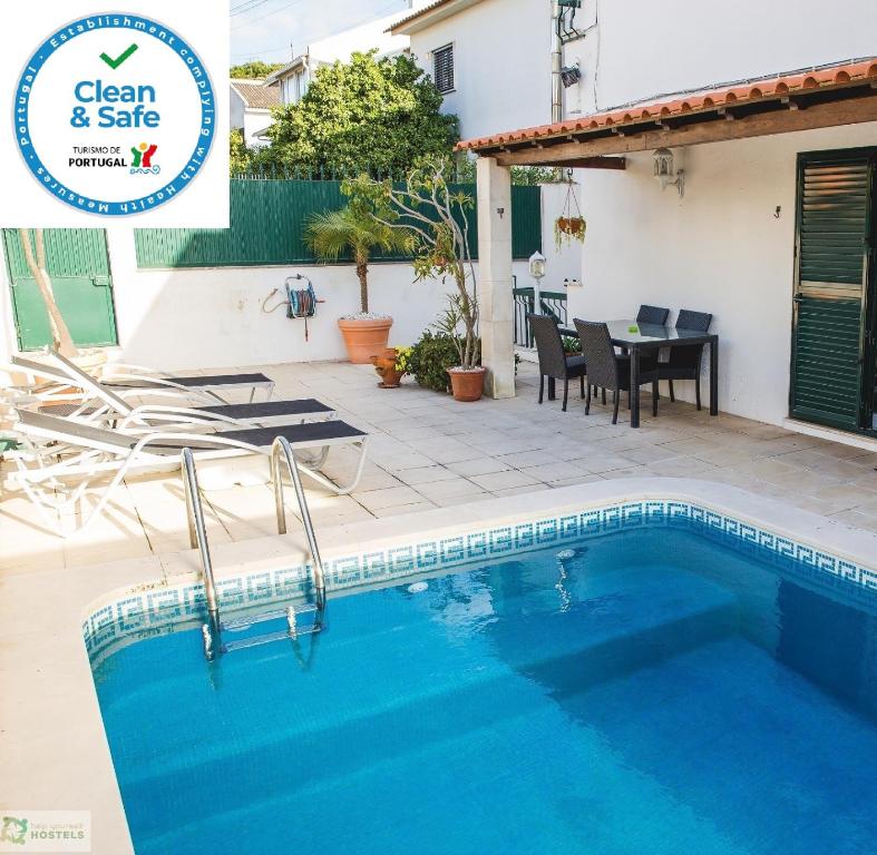 卡尔卡维洛斯Help Yourself Hostels - Carcavelos Coast的一座带游泳池和桌椅的房子