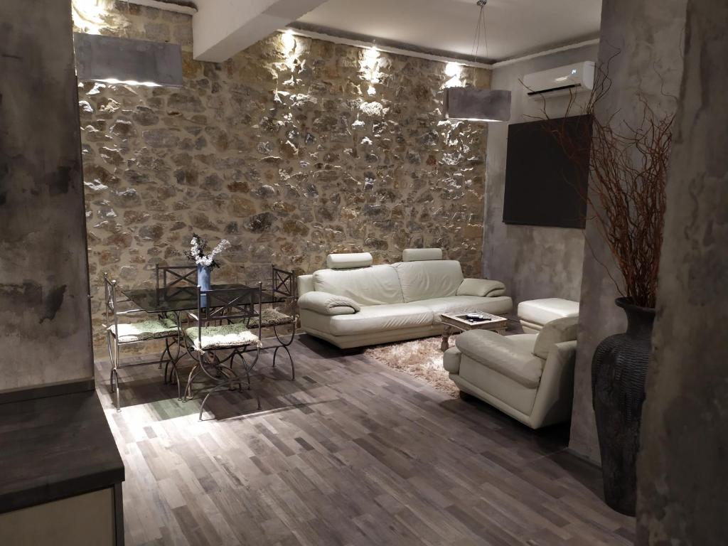 雅典Unique Luxury House的客厅配有白色家具和石墙