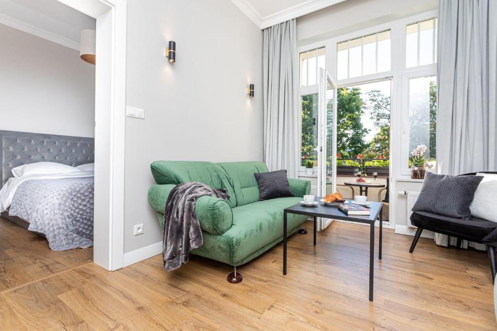 索波特Apartamenty Vincent Sopot的客厅配有绿色沙发和床。
