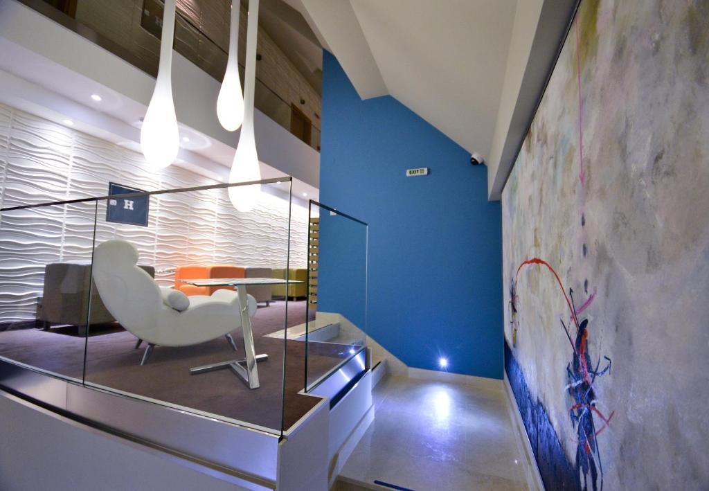 尼什嘉尼艺术洛夫特酒店的大堂配有白色椅子和桌子