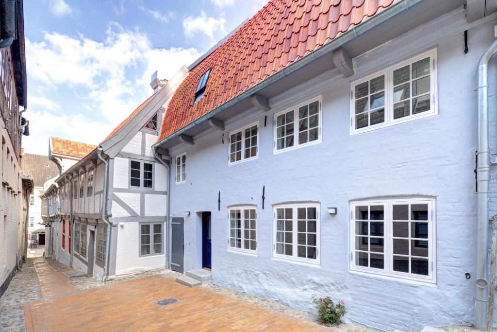 弗伦斯堡Ferienhaus Grosse 73, Flensburg的白色房子,有红色屋顶