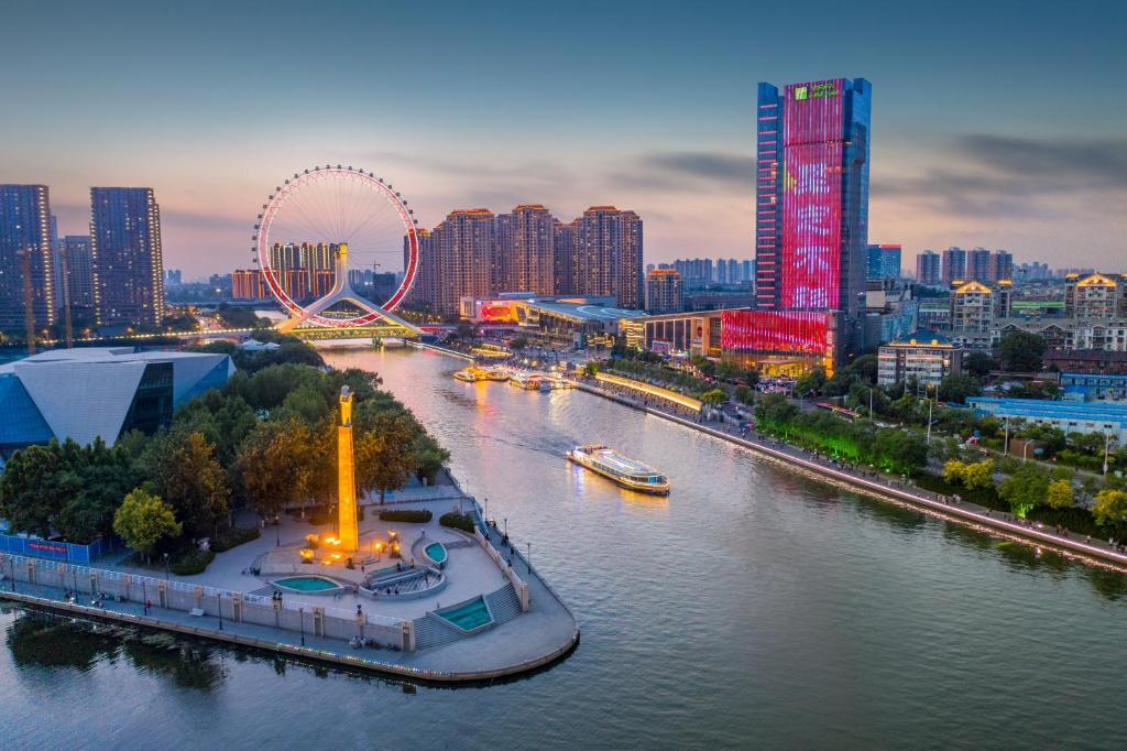 天津天津海河假日酒店的一座有河流的城市和一座有高楼建筑的城市