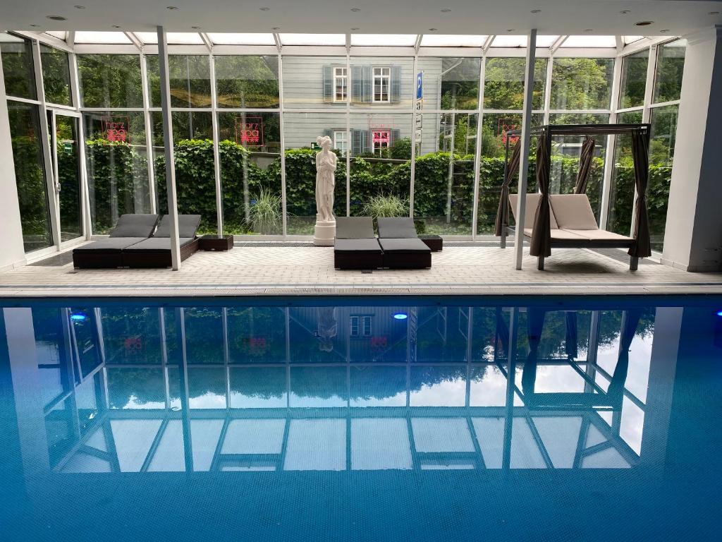 巴特哈尔茨堡Harz Hotel & Spa Seela的一座大楼前的游泳池,配有两把躺椅