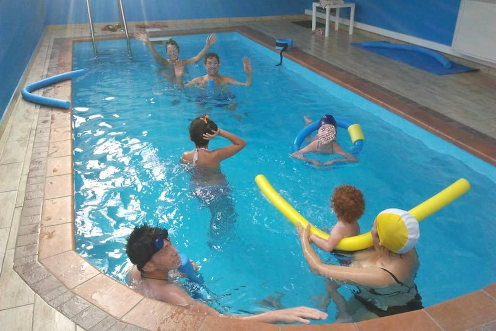 Santa Domenica TalaoCasaAltieri的一群人在游泳池玩耍