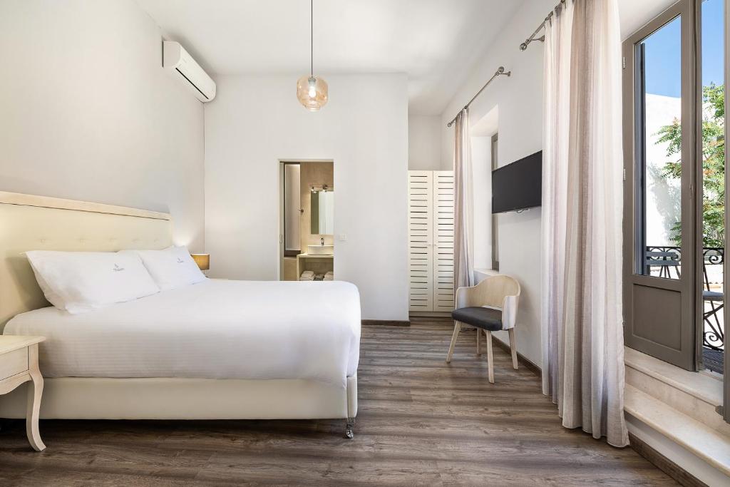 干尼亚Shalom Luxury Rooms Daliani的一间带白色床的卧室和一个阳台