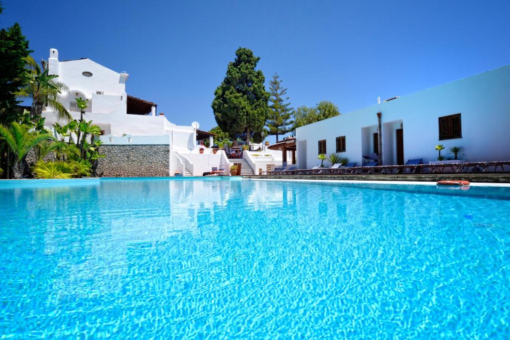 利帕里戈多帕多公园酒店的白色建筑前方的大型蓝色海水游泳池