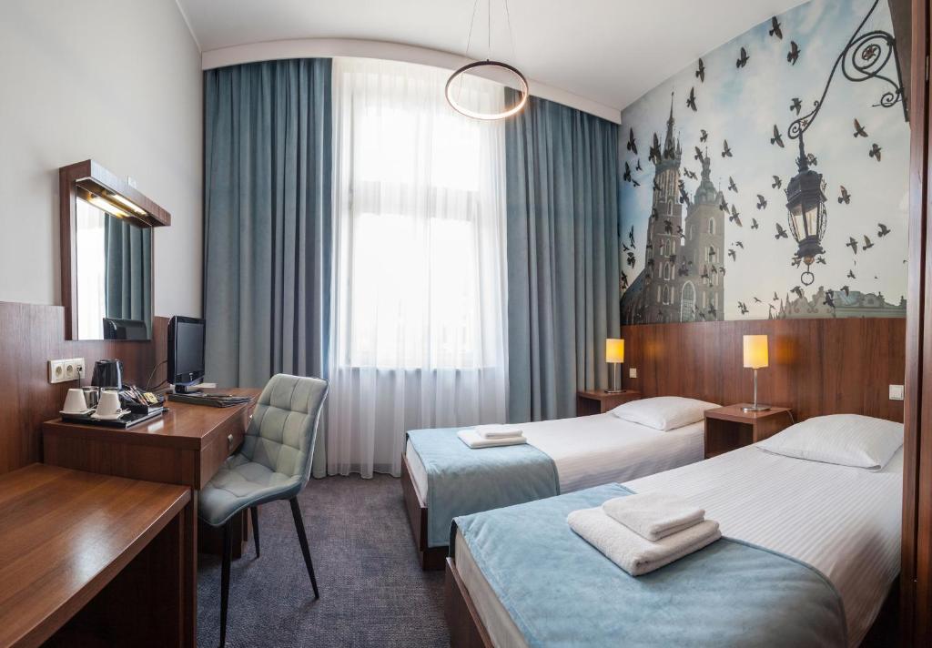 克拉科夫Hotel Downtown Kraków的酒店客房配有两张床和一张书桌