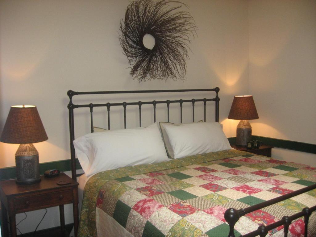 盖茨堡布拉弗顿住宿加早餐旅馆的一间卧室配有一张带被子和两盏灯的床。