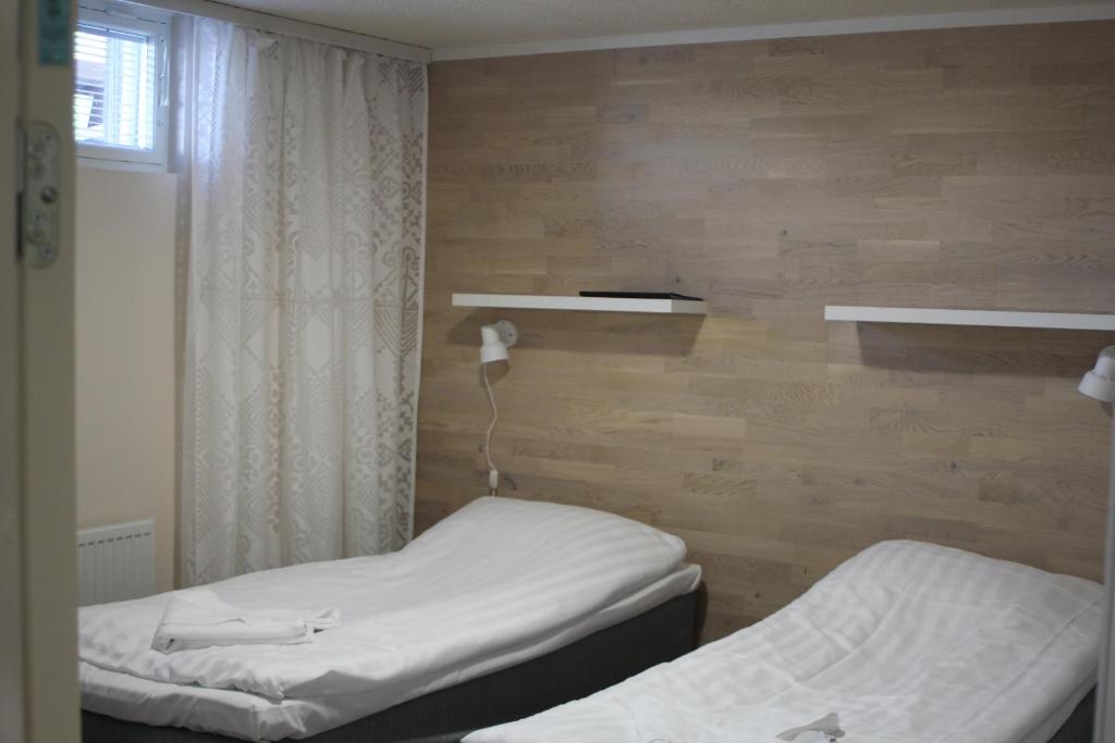 VolttiJääskän Loma, Kojolapark Luiska-hostelli的客房设有两张床、窗户和架子。