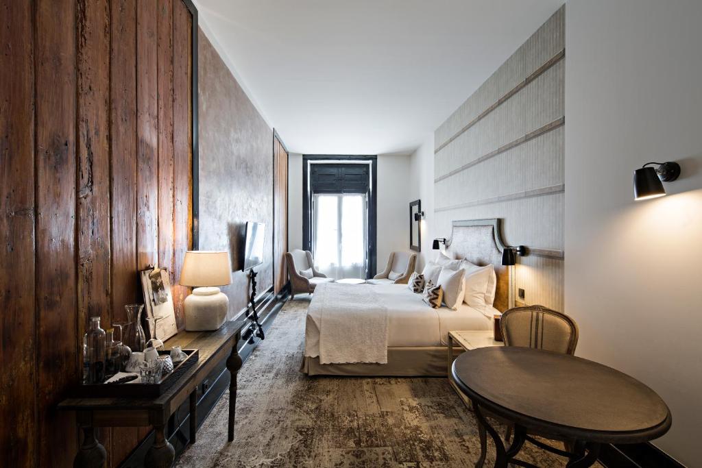 里斯本阿尔玛卢飒拜萨希亚多酒店的酒店客房配有一张床铺和一张桌子。