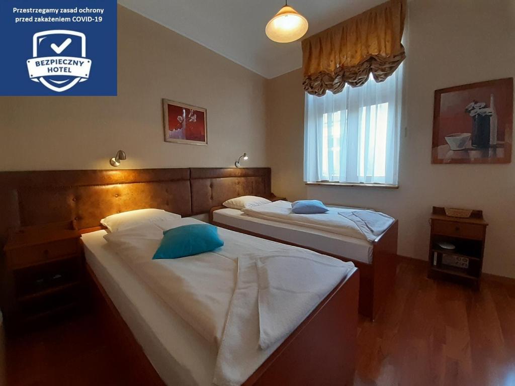 克拉科夫卡齐米秘密酒店的一间卧室设有两张床和窗户。