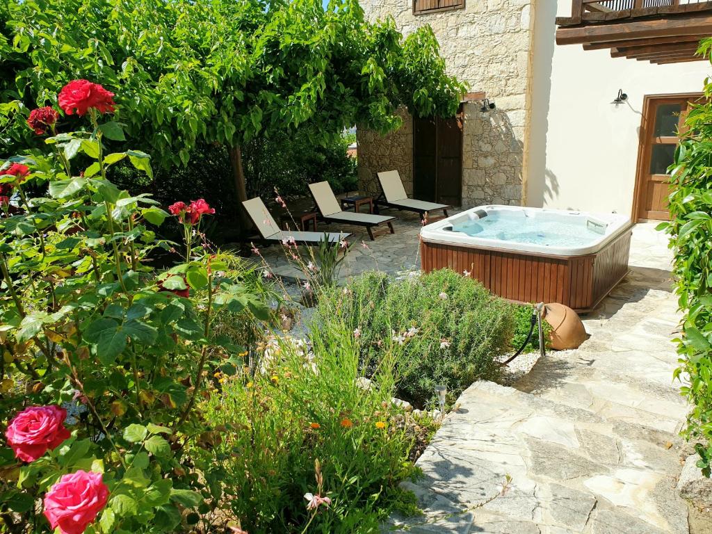 LysoSea and Mountain View Villa Anna的花园,花园内设有一个热水浴缸,庭院内种有玫瑰