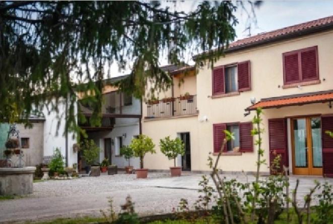 Bagnoli di SopraB&B Da Castello的一座带红色百叶窗的建筑和一个庭院