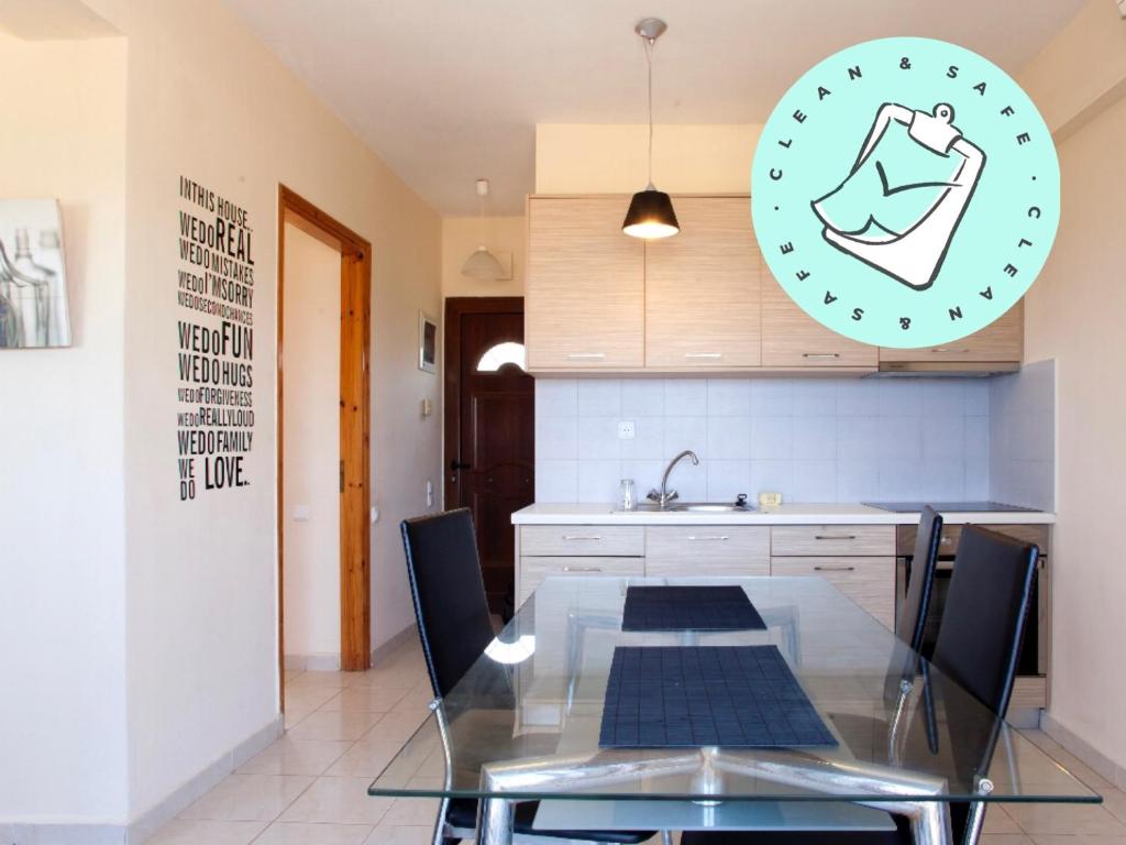 锡蒂亚Makis Apartments的厨房配有玻璃桌、椅子和水槽