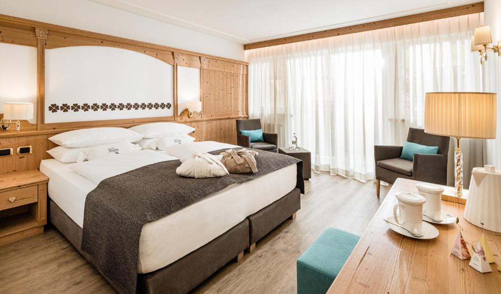 塞尔瓦迪加尔代纳山谷Giardin Boutique Hotel B&B的酒店客房带一张大床和一把椅子