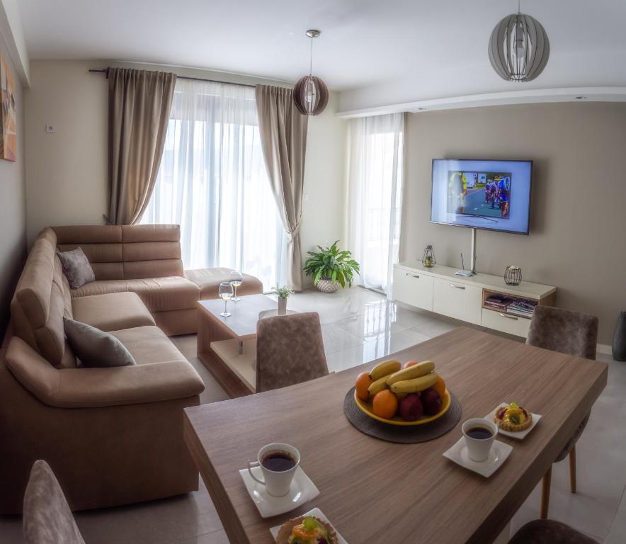 蒂瓦特Ralux apartman Tivat的客厅配有桌子和沙发