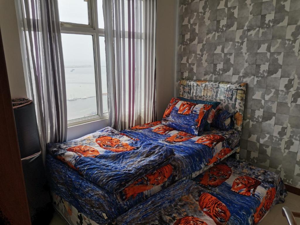 雅加达4 Bed Condo Sleeping by The Sea的卧室窗户旁的一张床