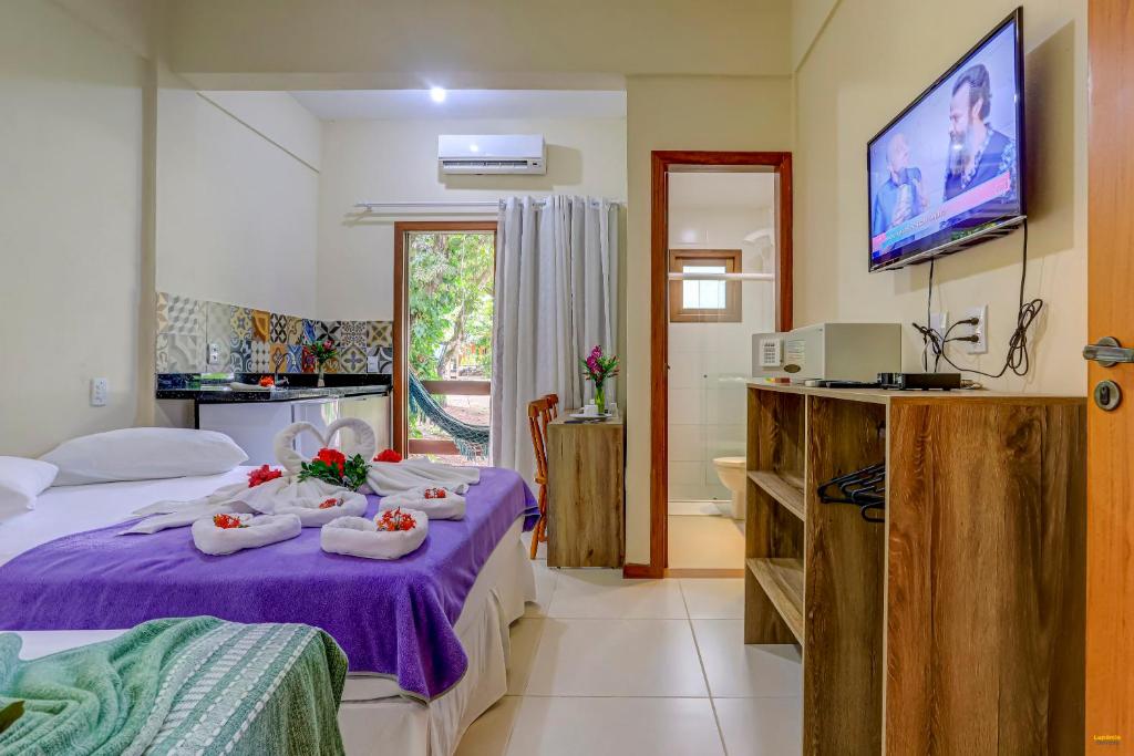 伊塔卡雷i9 Quixaba Flat的酒店客房设有紫色床和浴室。