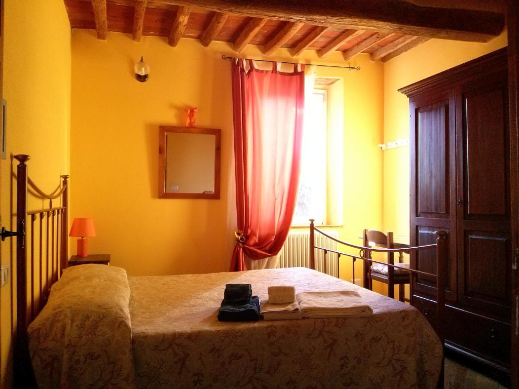 马萨罗萨La Coccinella di Silvia e Simone的一间卧室配有一张带红色窗帘的床和窗户