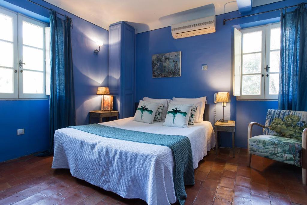 卡西斯爱弥儿花园酒店的蓝色卧室,配有床和椅子