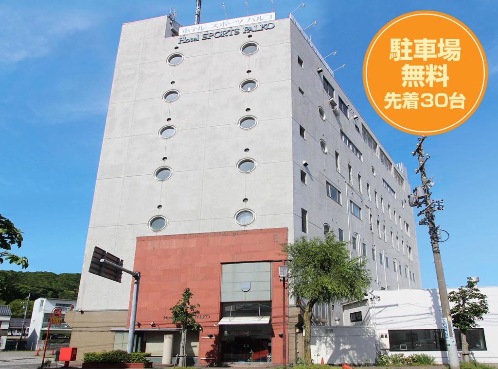 岐阜Hotel Sports Palko的前面有标志的高大的白色建筑
