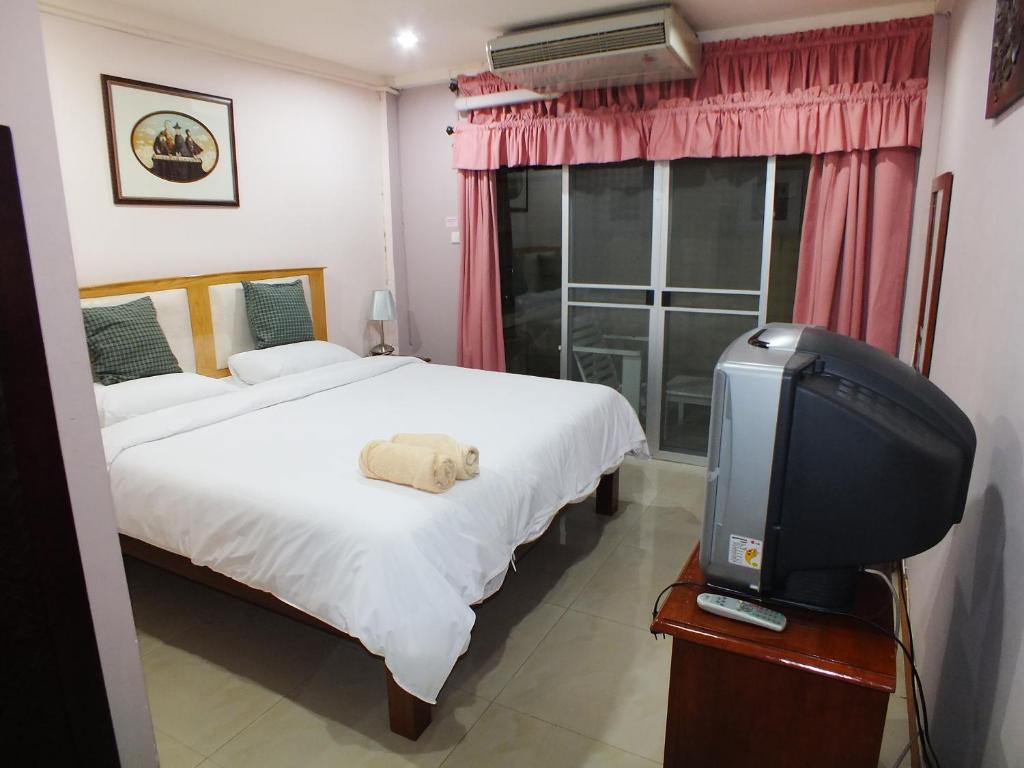 曼谷PR之地酒店的一间卧室配有一张床和一台电视。