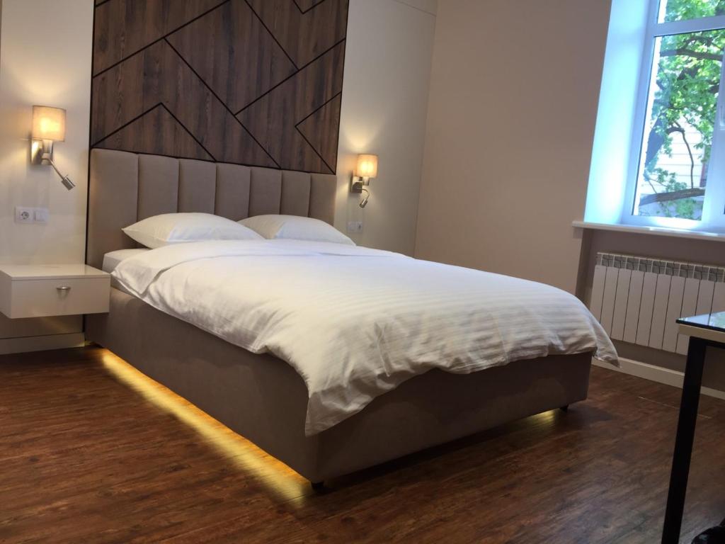 基辅Современный минимализм в центре Киева.的一间卧室配有一张大床和木制床头板