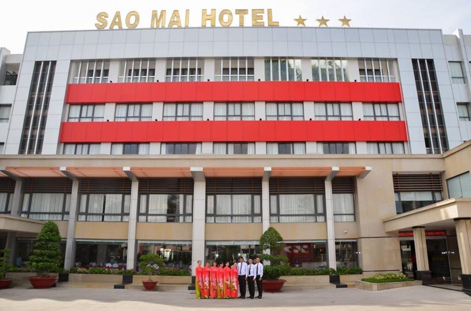 Cao LãnhKHÁCH SẠN SAO MAI的两个男人站在一个Sao mol酒店前