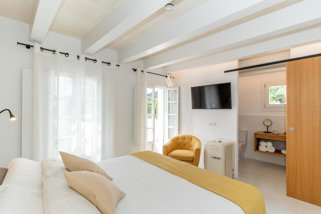 埃斯·梅卡达尔Hotel m - 27的白色的卧室配有白色的床和电视。