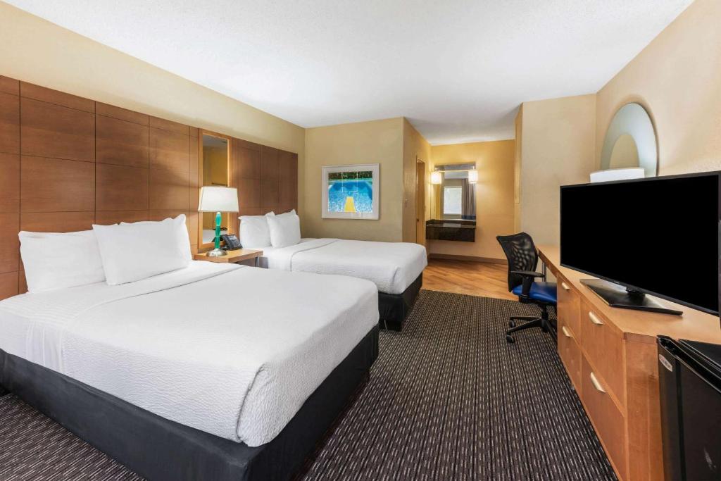 劳德代尔堡La Quinta by Wyndham Fort Lauderdale Pompano Beach的酒店客房设有两张床和一台平面电视。