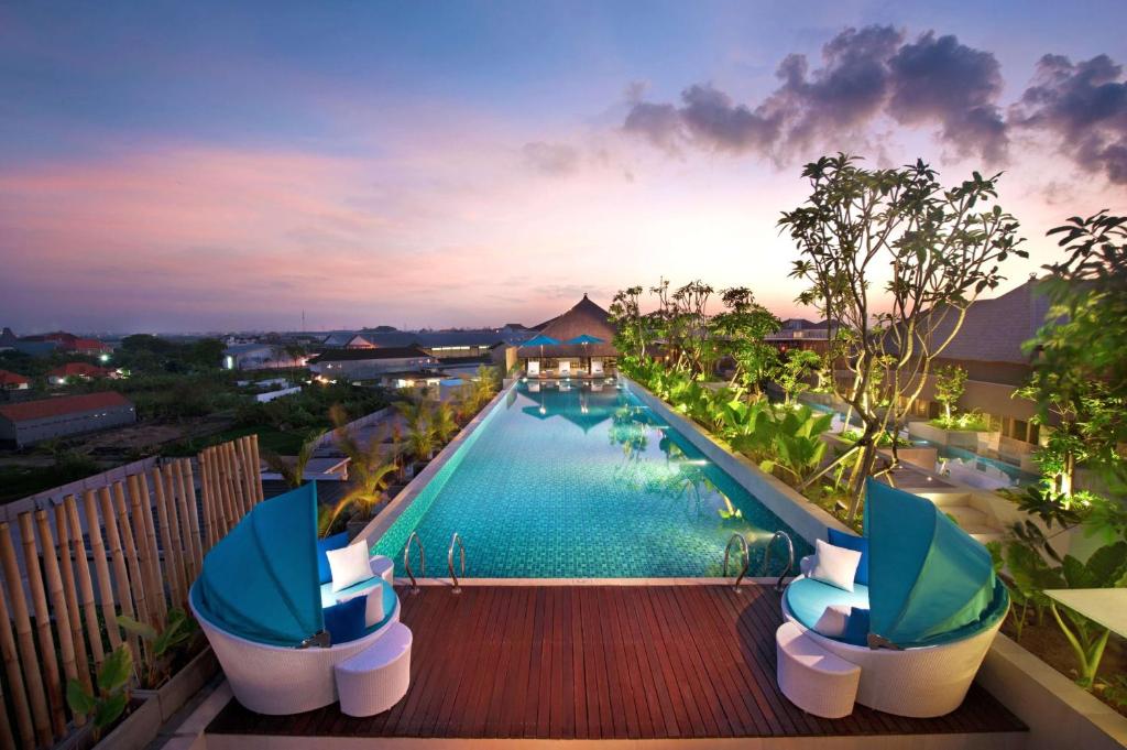 库塔巴厘岛库塔日落路温德姆华美达酒店的享有度假村游泳池的景致