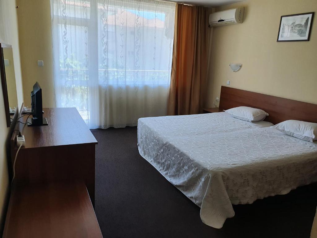 内塞伯尔桑德尔酒店的一间卧室配有一张床、一张书桌和一个窗户。