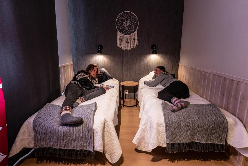 KiviperäIsokenkäisten Klubi - Wilderness Lodge的一群人躺在房间里的床上