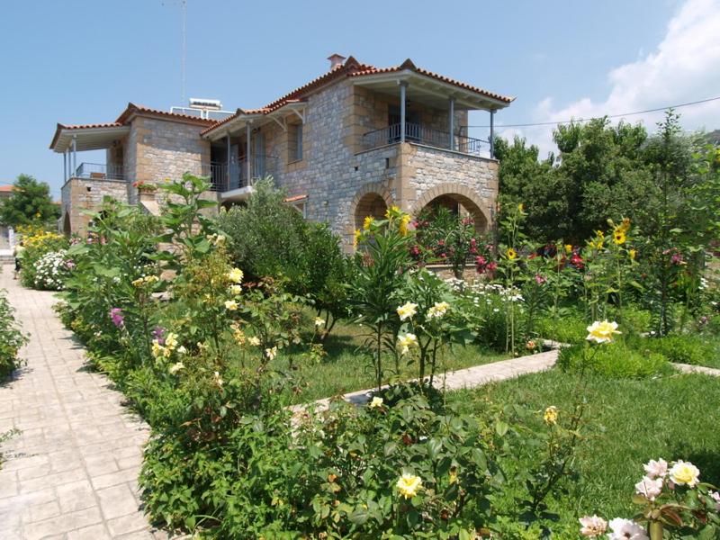 斯陶帕angelastudios-stoupa的一座房子,前面有一个种着鲜花的花园